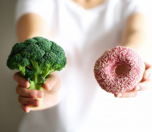 chica cogiendo donut y brocoli
